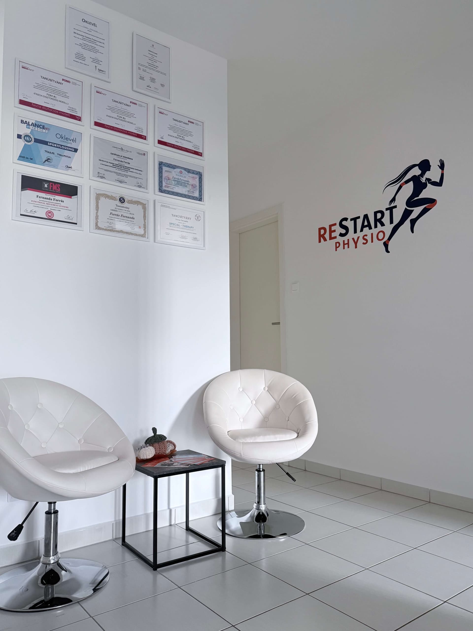ReStart Physio váróterme kényelmes székekkel és oklevelekkel.